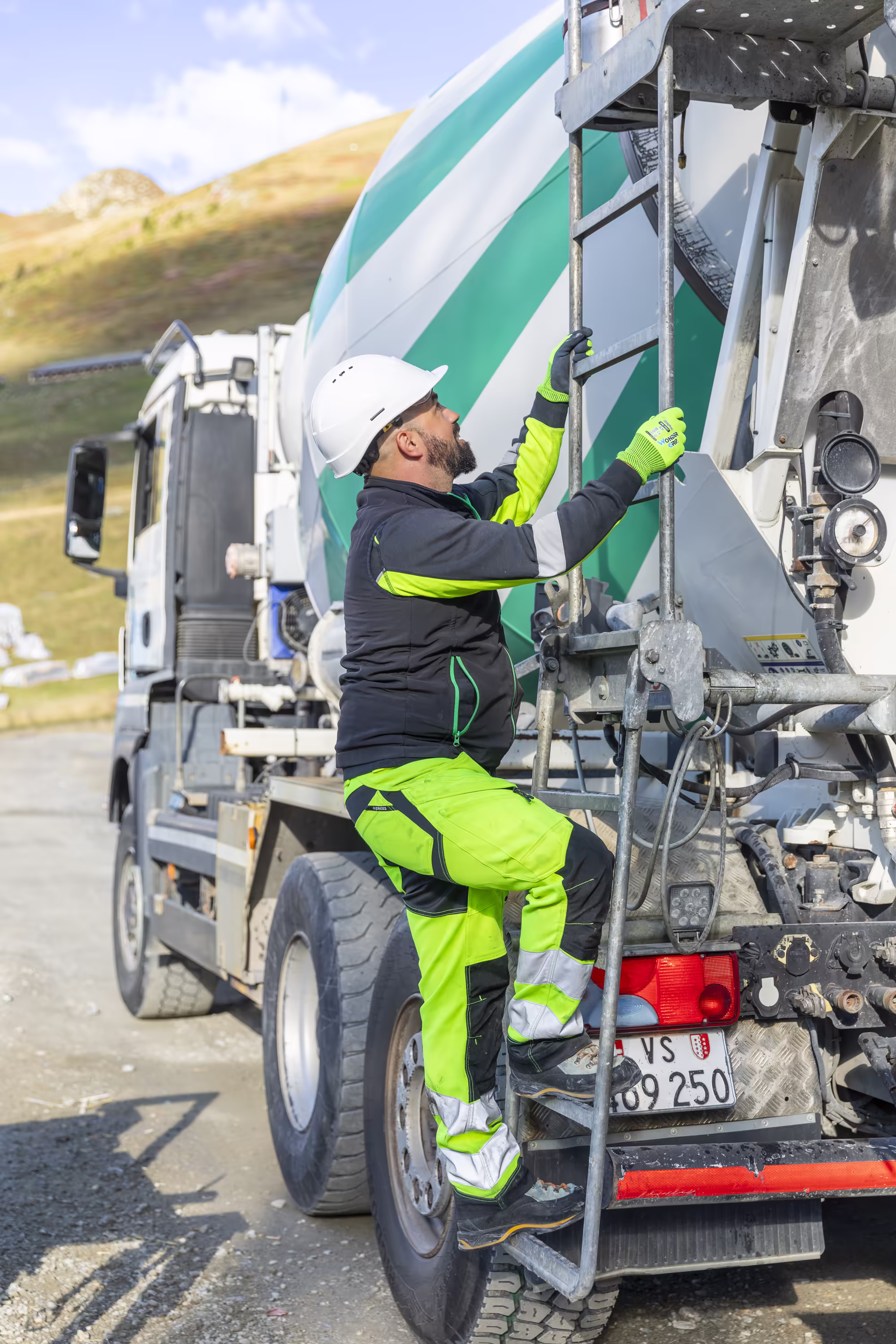 Un ouvrier monte à l'échelle d'un malaxeur