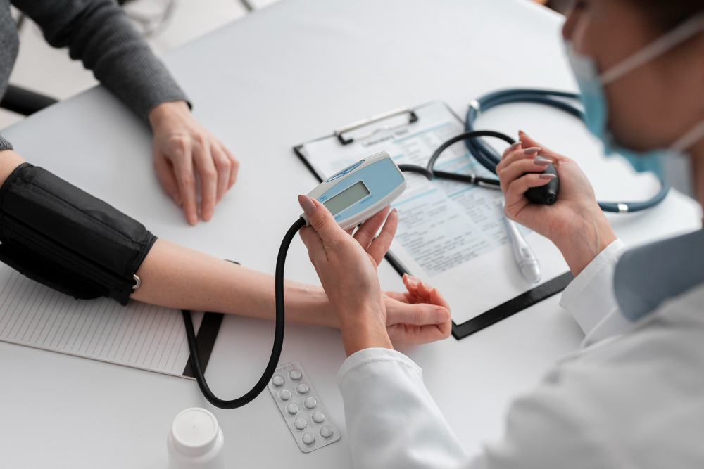 Healthcare professional measuring blood pressure of a patient with a digital monitor in a medical office.