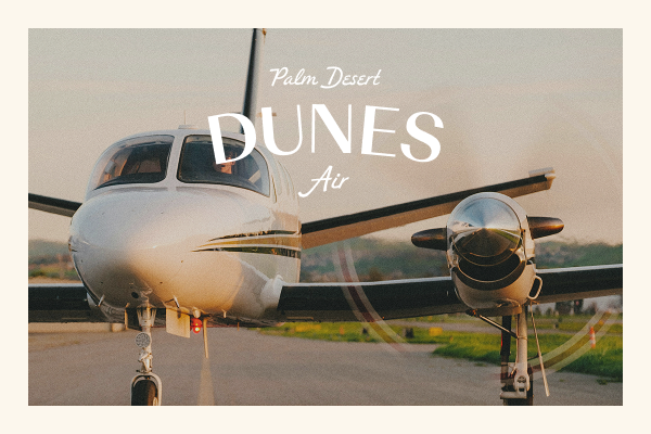 Front view of a small white airplane on a runway at sunset with text reading 'Palm Desert Dunes Air'.