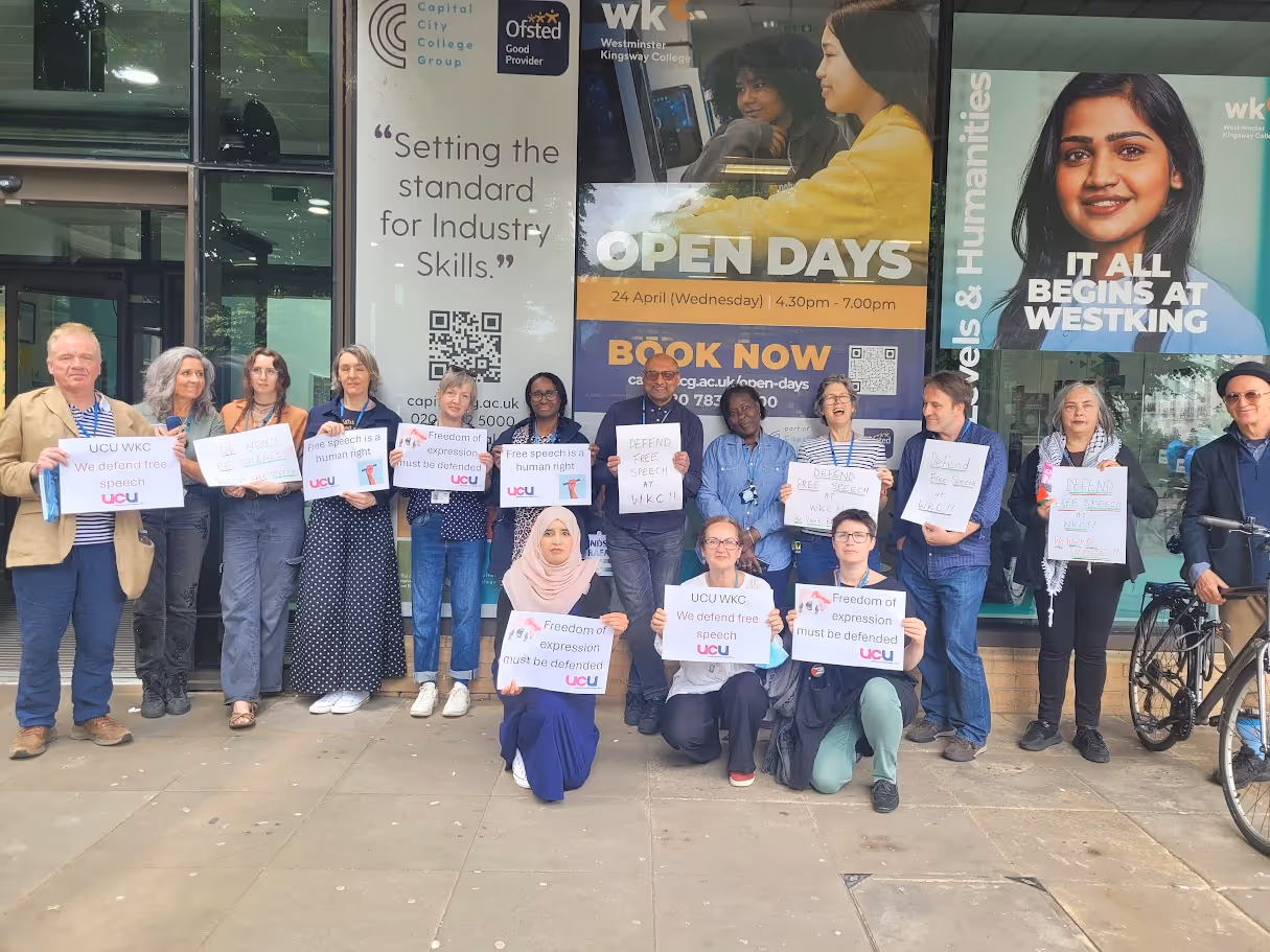 Group of people standing outside Westminster Kingsway College holding signs supporting free speech and freedom of expression.