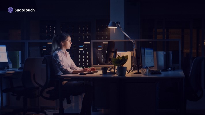 Women in dark room looking at computer screen.