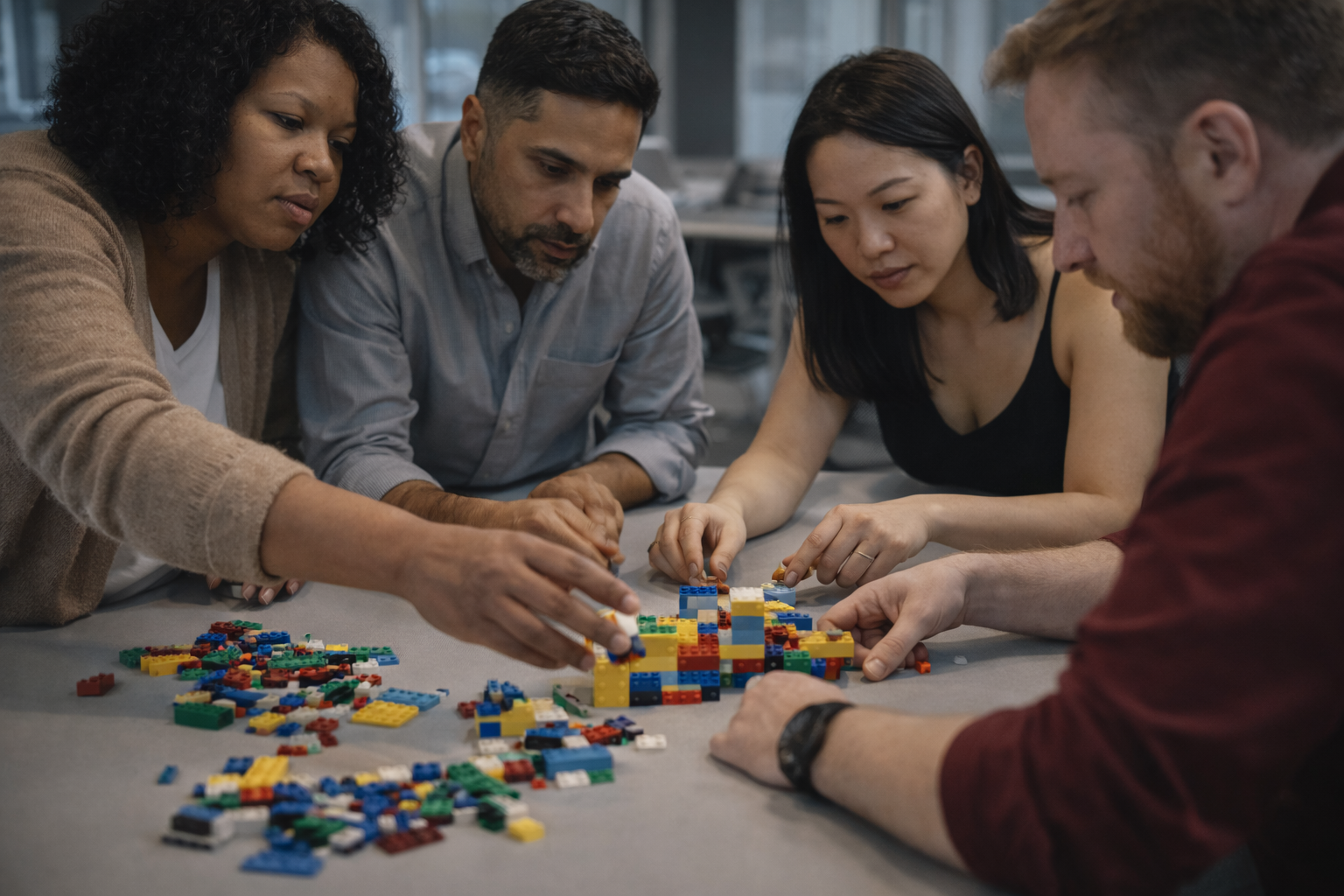 Office group watching a man in a blue shirt showing a metal bowl to a woman wearing a protective cape.