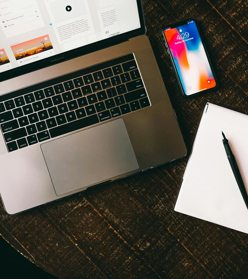 Product design workspace with laptop, phone and notebook