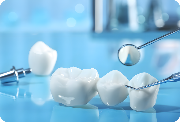 Close-up of dental tools and three white dental crowns on a reflective blue surface.