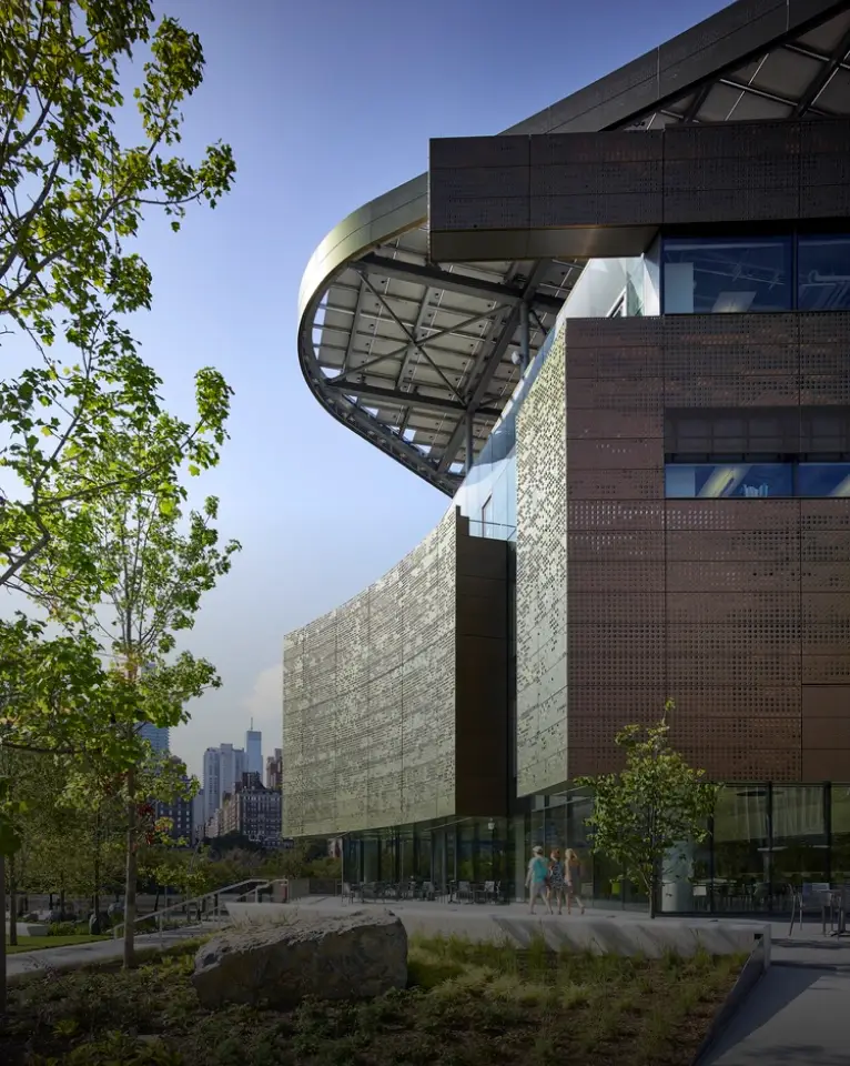 Sunset over a desert landscape with multiple high-voltage power lines and transmission towers stretching into the distance.