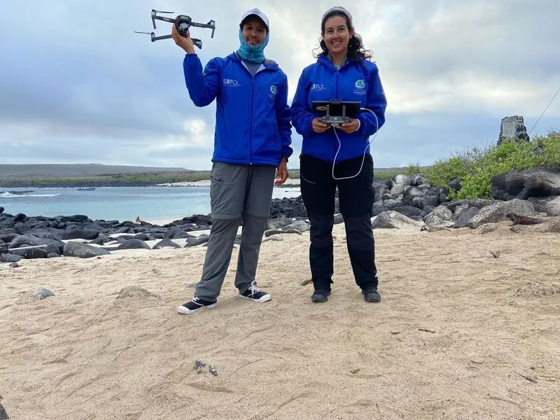 Two members from the expedition on the beach holding drones