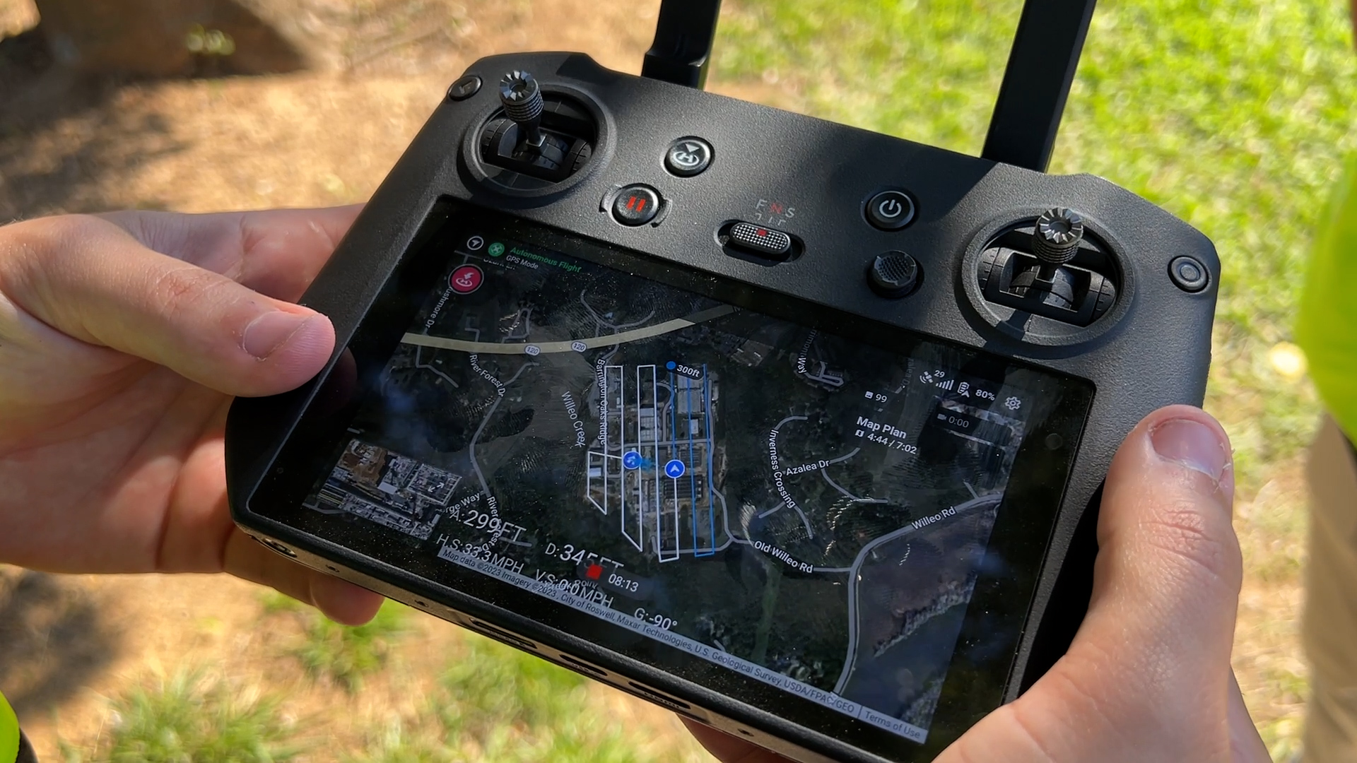 Over the shoulder photo of someone performing a drone survey using the Mavic 3E controller