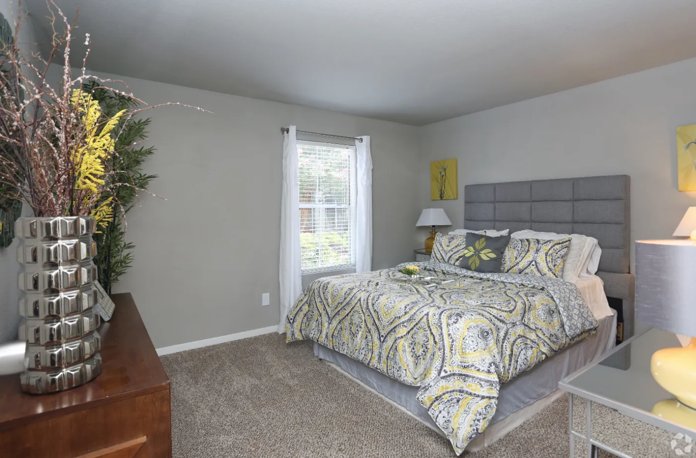 bedroom with bed and dresser with plant