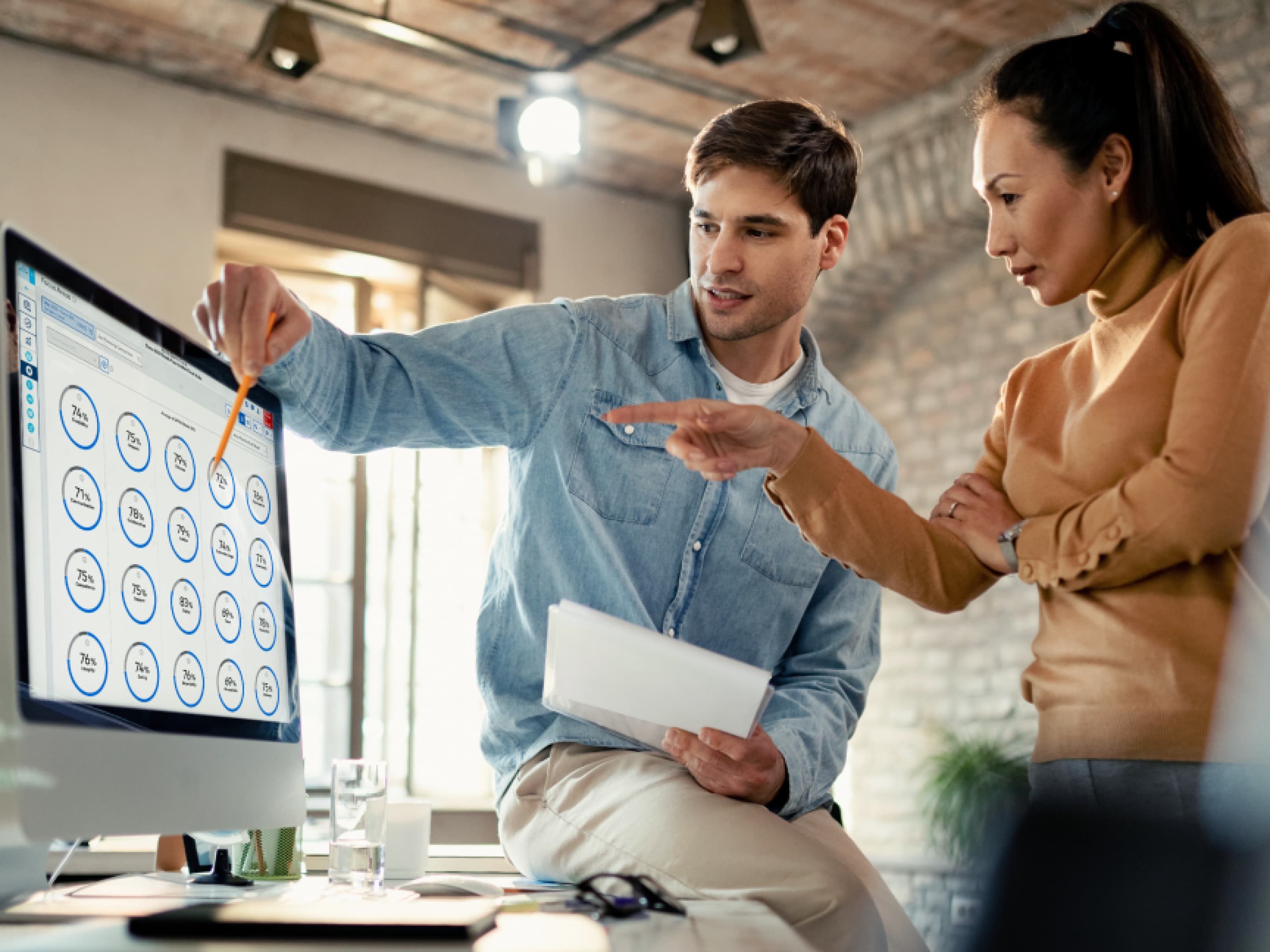 Man and woman discussing Great Place To Work data shown on a computer.