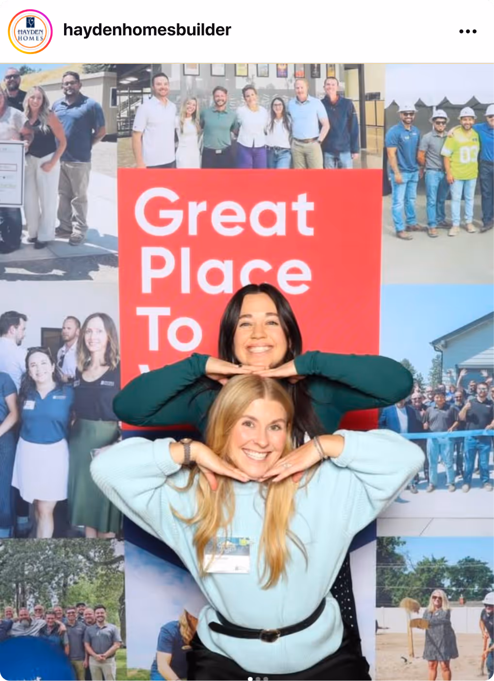 Two people posing in front of a display wall featuring photos and a large Great Place To Work Certification badge.