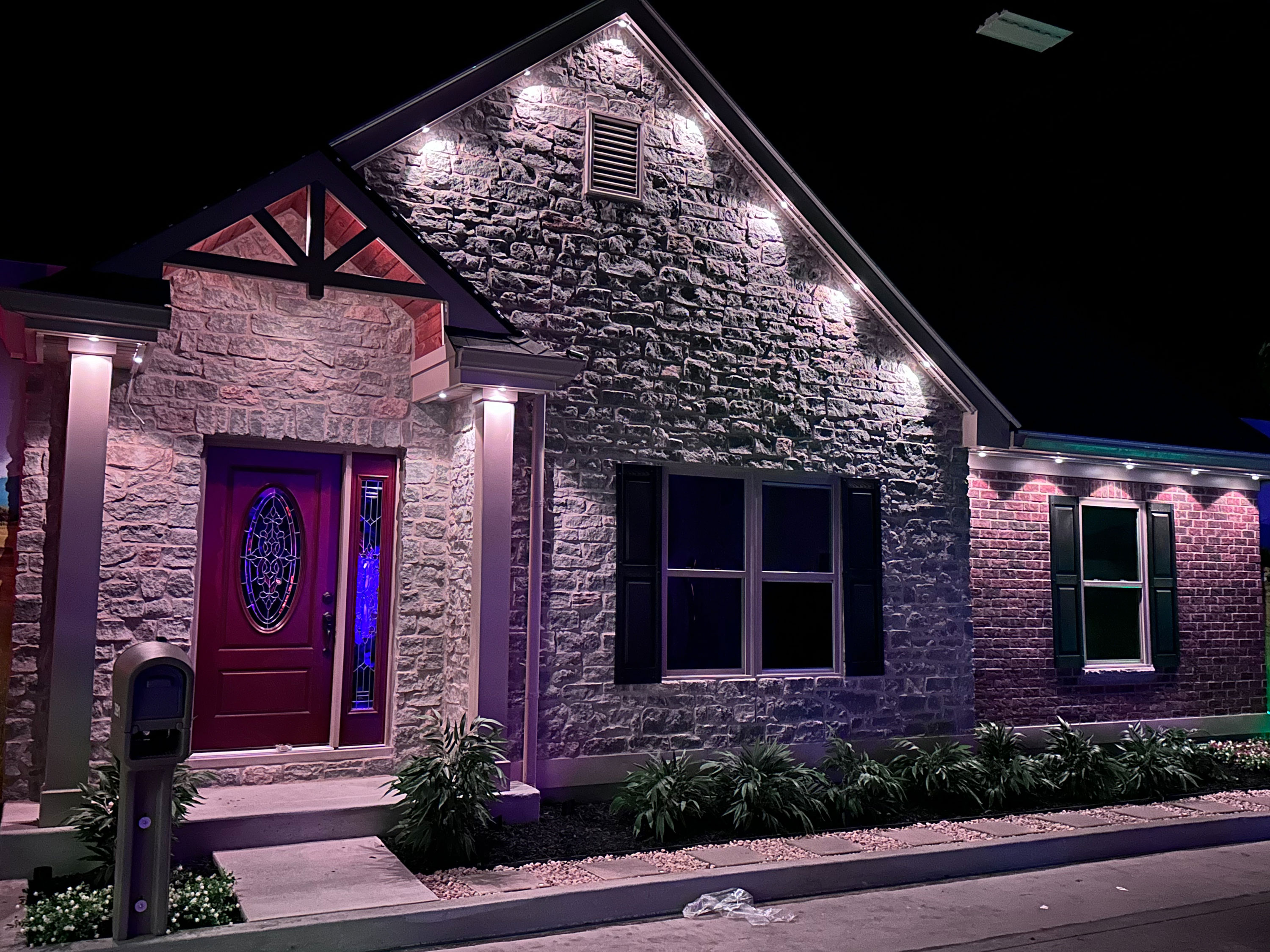 Permanent outdoor lighting installation on a residential property, showcasing professionally mounted LED lights along the roofline and architectural features. The image highlights durable permanent lighting solutions that enhance nighttime curb appeal and outdoor ambience for homes.