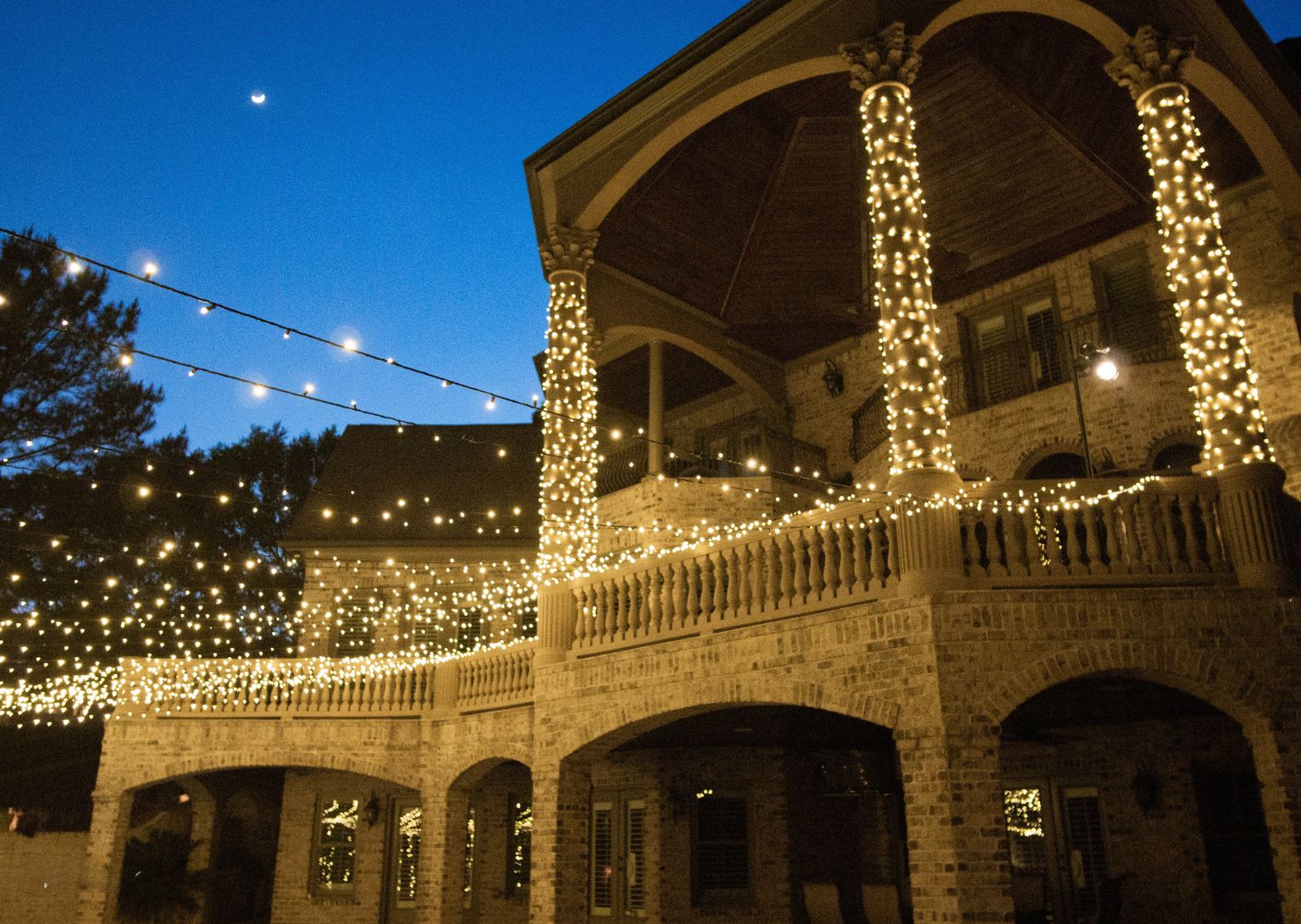 Holiday lighting installation on a residential home at night with vibrant LED Christmas lights outlining the roofline and windows, creating a festive and inviting seasonal atmosphere.