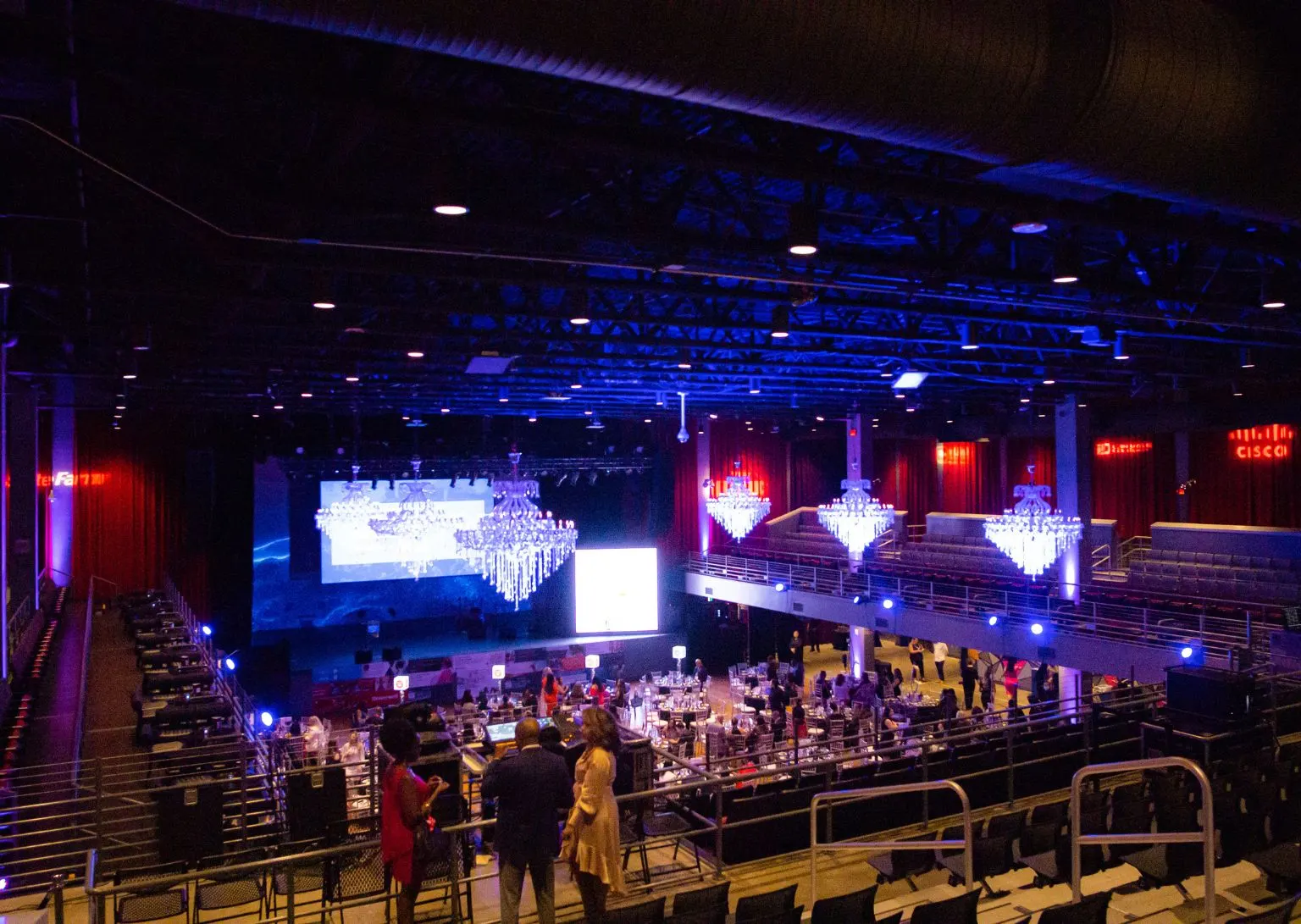 Event lighting installation featuring a stunning chandelier of hanging LED lights in a sports arena, creating a dramatic and captivating atmosphere. The lighting design enhances the venue with vibrant blue and white lights, perfect for large-scale events and special occasions, like those hosted at Georgia Tech."