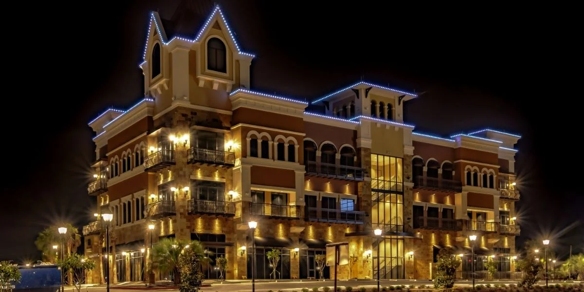 user-inserted Commercial architectural lighting on a modern building facade with uplighting and trim lights.