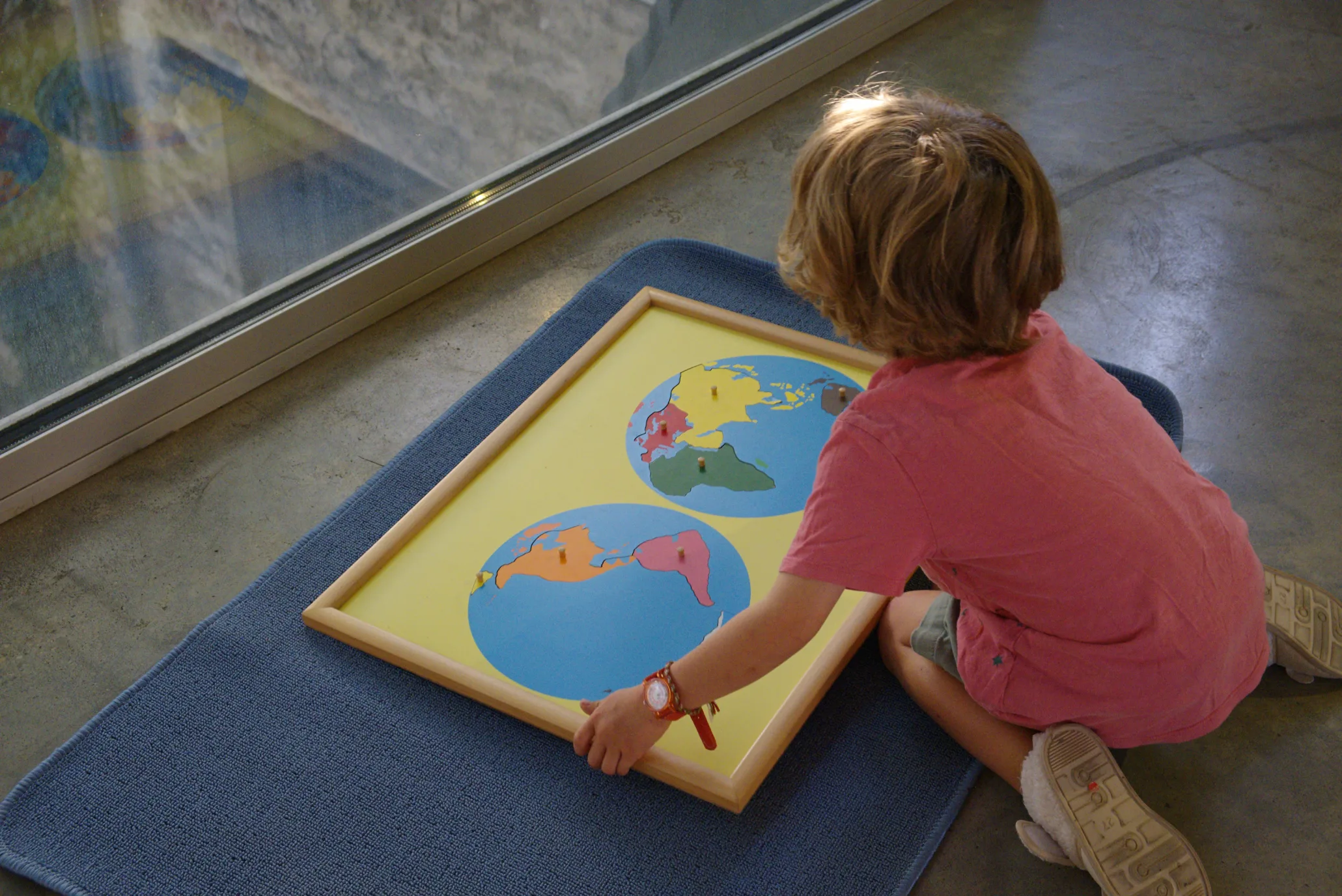 Un enfant fait un puzzle du monde