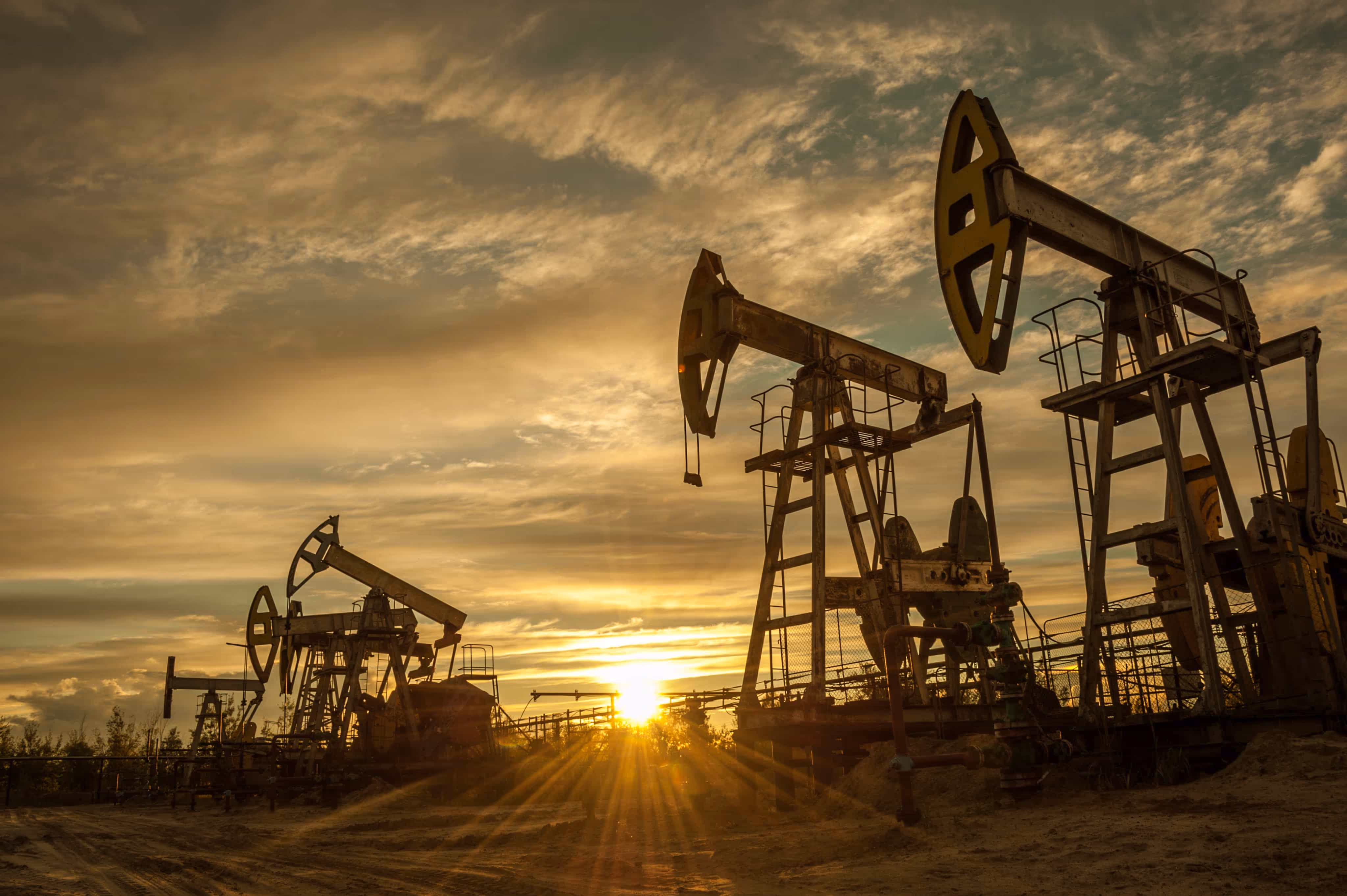 Oil field pump jacks at sunset representing Karve Energy field remediation operations, where Matidor is used to track every remediation dollar and manage project budgets within 1 percent.