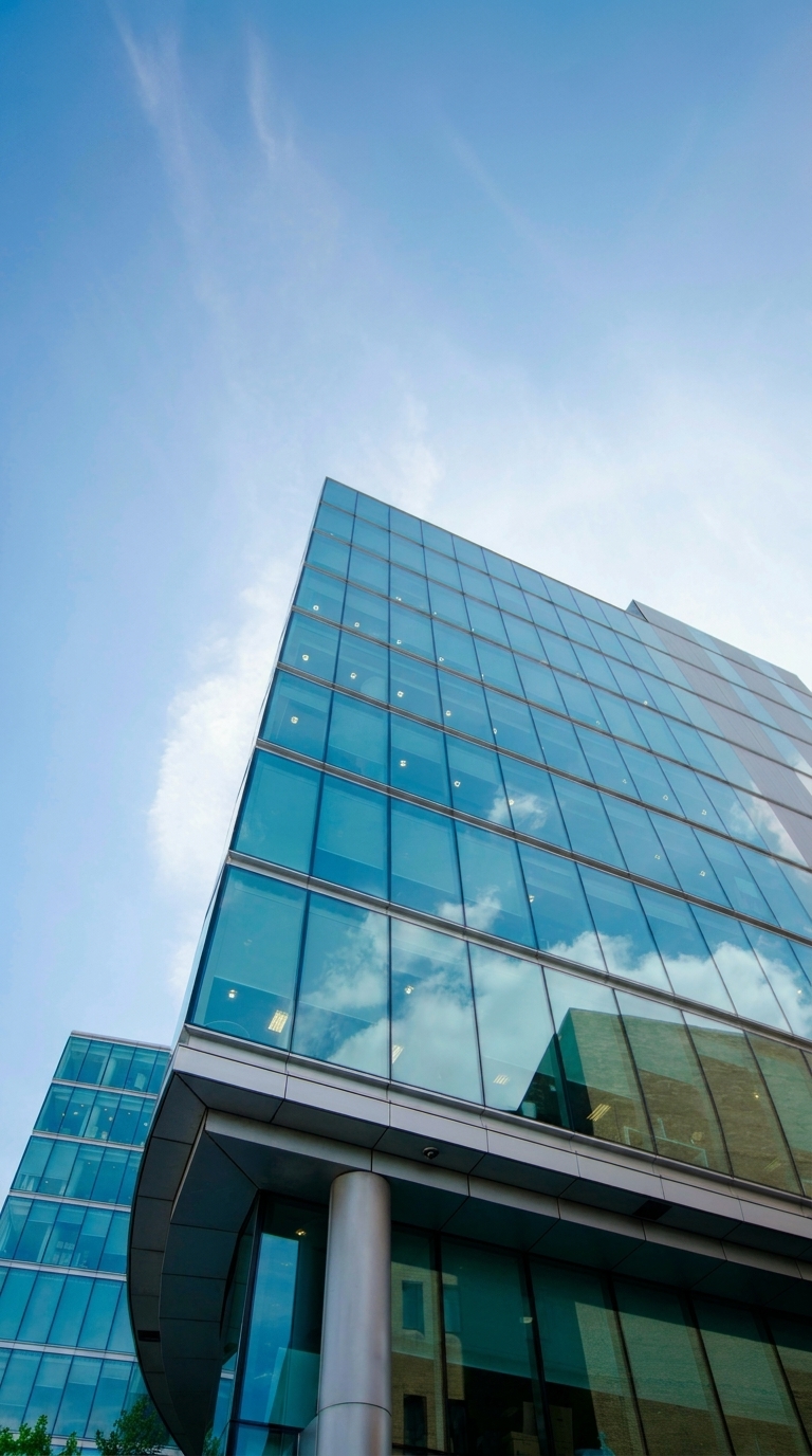 Modern glass office building against a blue sky representing Earthmaster Environmental Strategies Inc. headquarters in Calgary, a professional environmental consulting firm serving complex oil and gas and industrial projects.