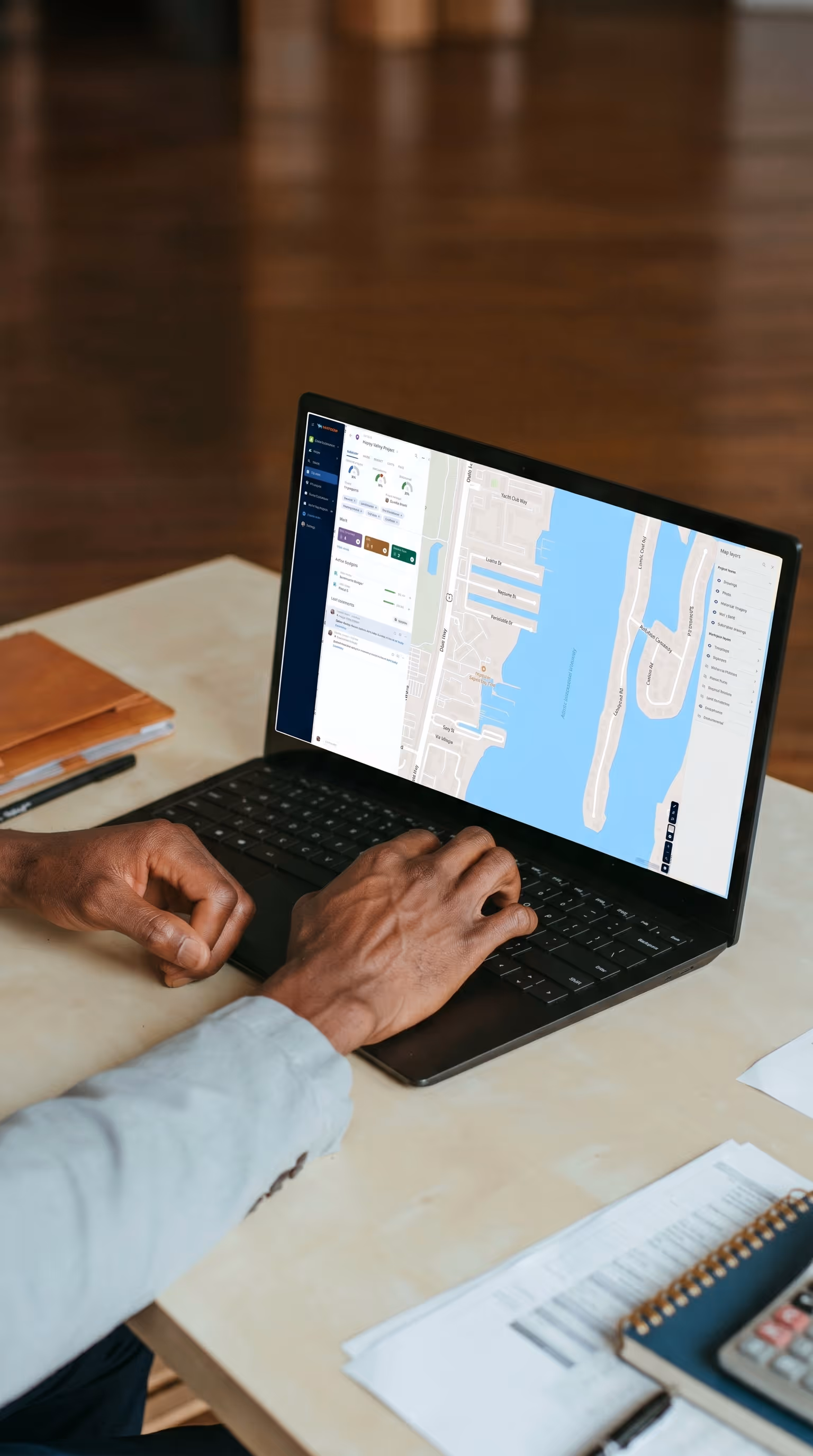 Project manager typing on a laptop showing the Matidor platform with a project management dashboard and GIS map view, representing how NorthWind Land Resources uses Matidor's field operations module with 15 or more standardized custom forms to centralize field data collection, reduce missing notes, and get field data to the office faster.