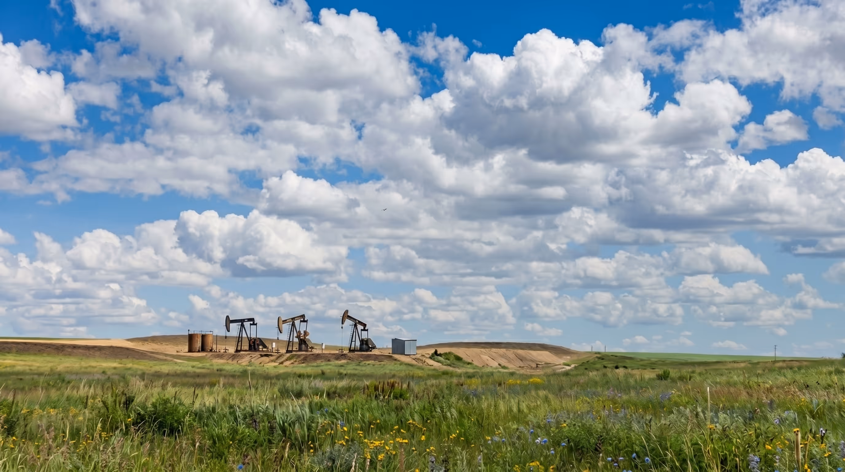 Alberta oil and gas landscape showing remediation and reclamation sites managed by Rife Resources across rolling grasslands and waterways