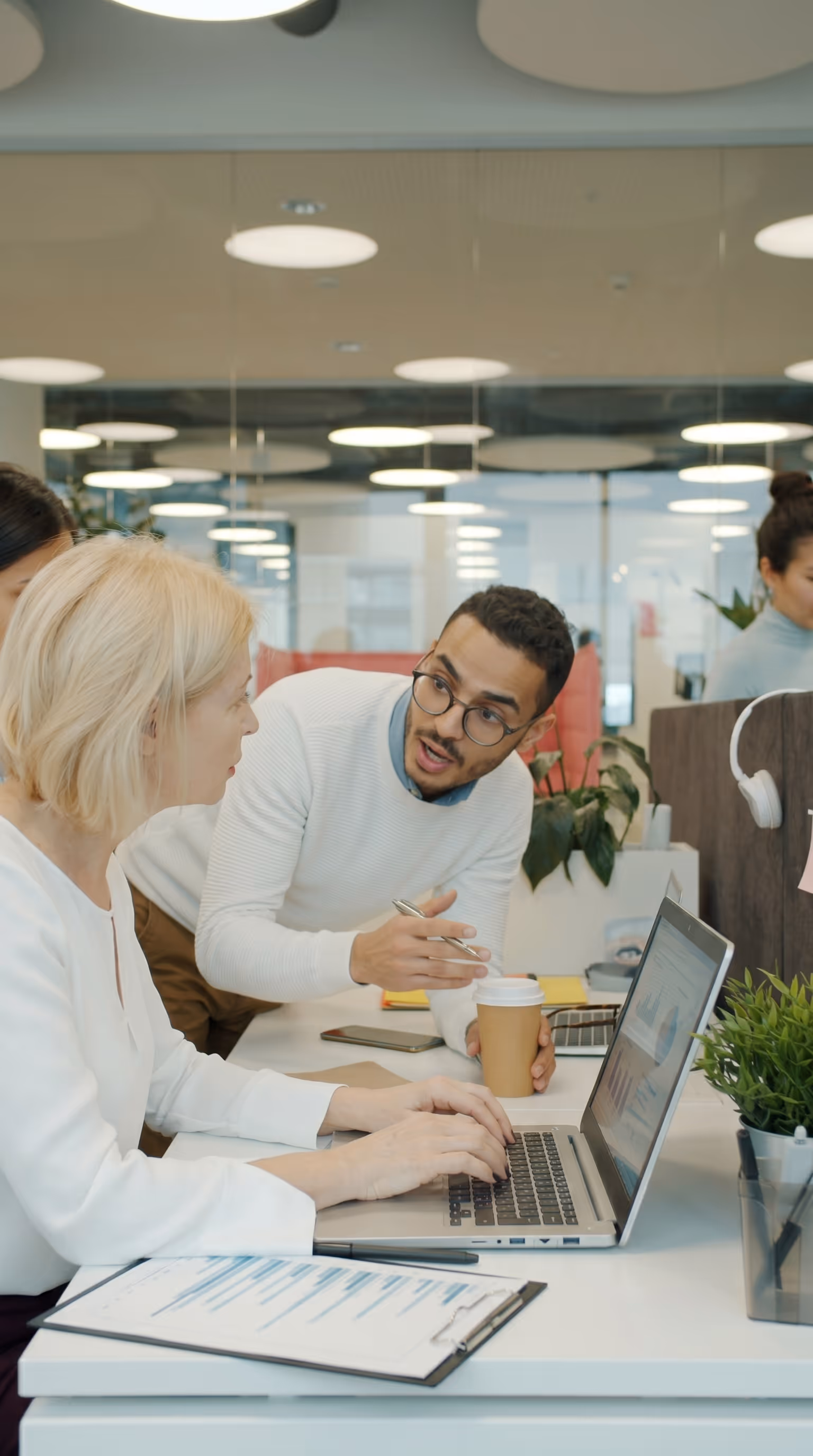 Two team members reviewing project data together on a laptop in a modern office, representing the improved vendor coordination and communication enabled by centralizing site data in Matidor
