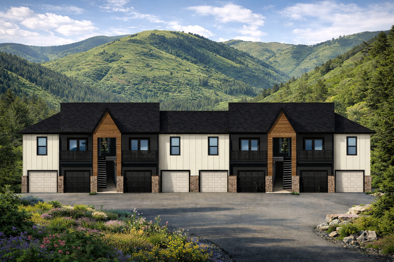 Modern multi-unit residential building with garages and balconies set against green forested hills under a blue sky.