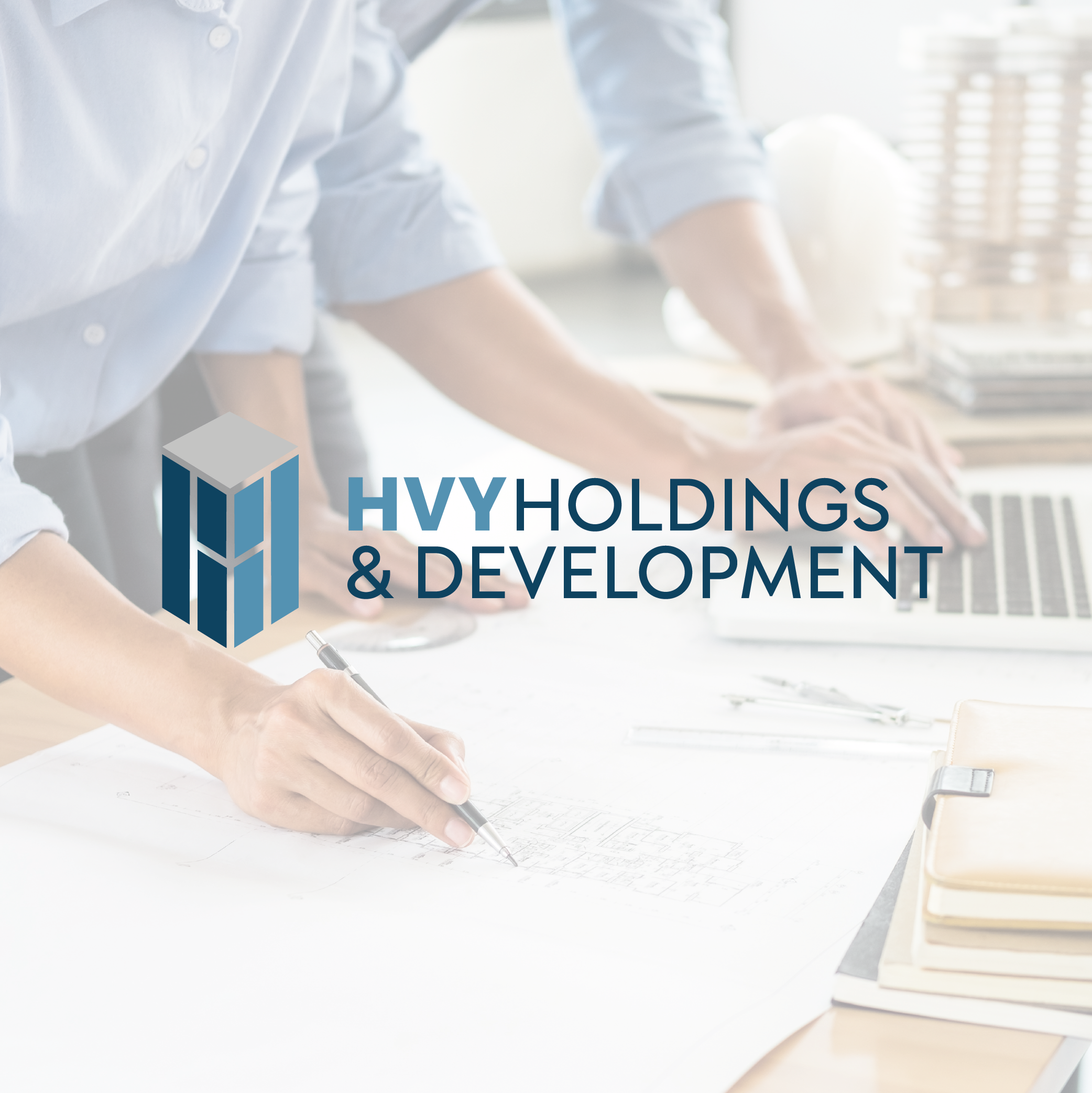 HVY Holdings & Development logo over a workspace with architectural plans, a person drafting with a pen, a laptop, and a model building.