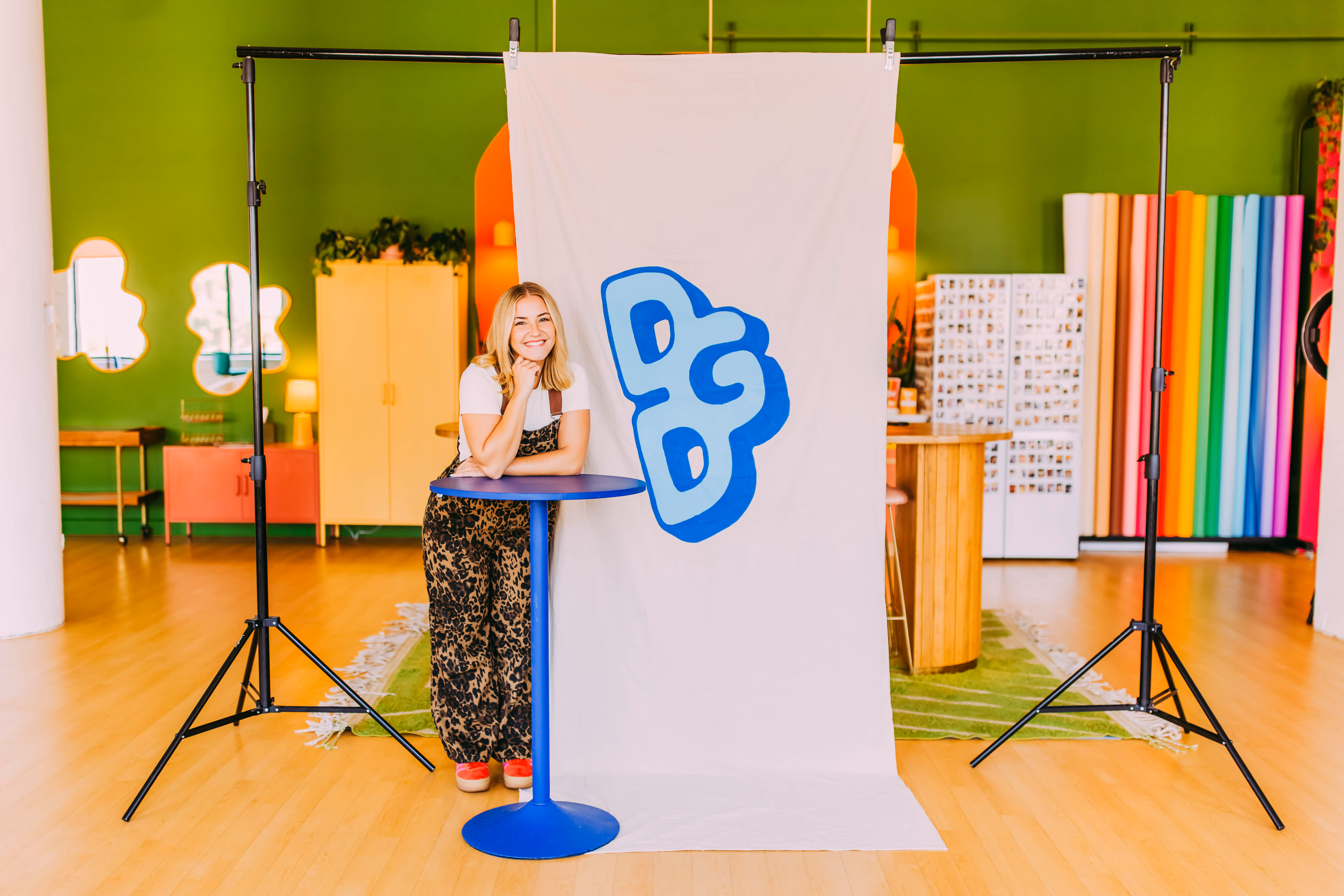 Allie, owner of the Do Good Designer, next to a hand painted mural.