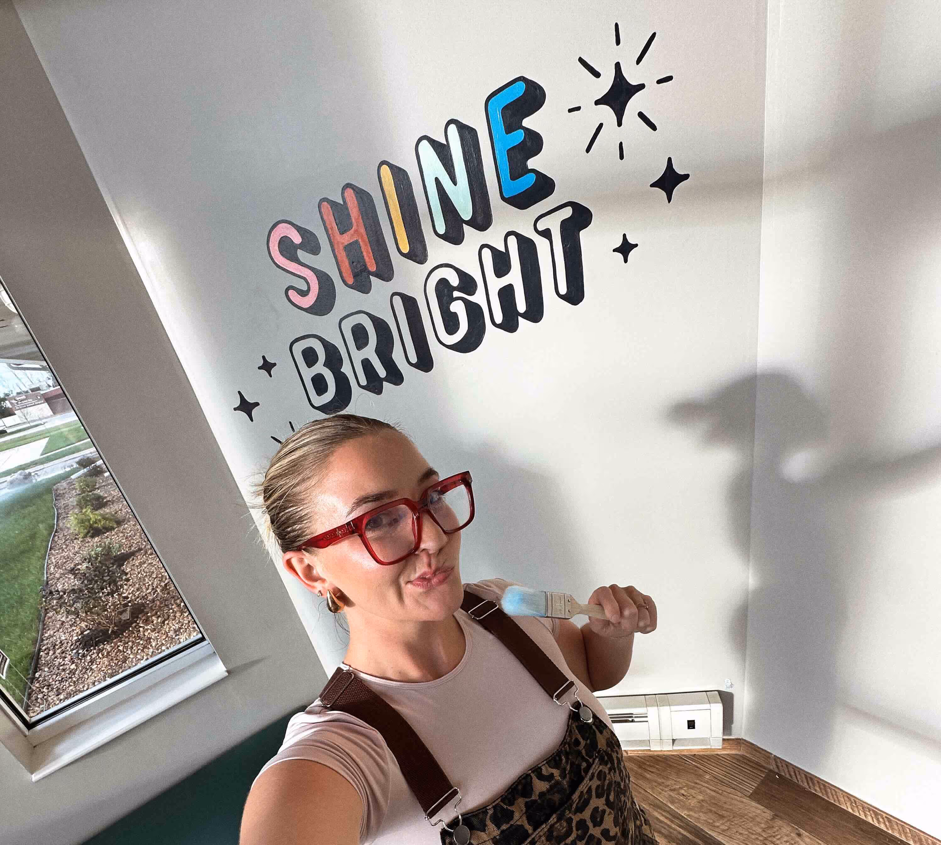 Designer standing next to mural art