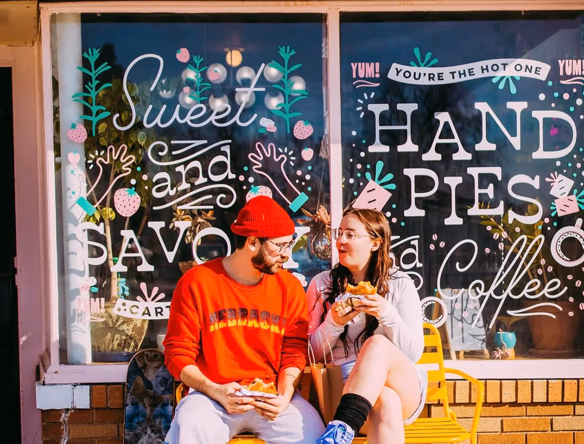 A couple enjoying food behind the business mural window design