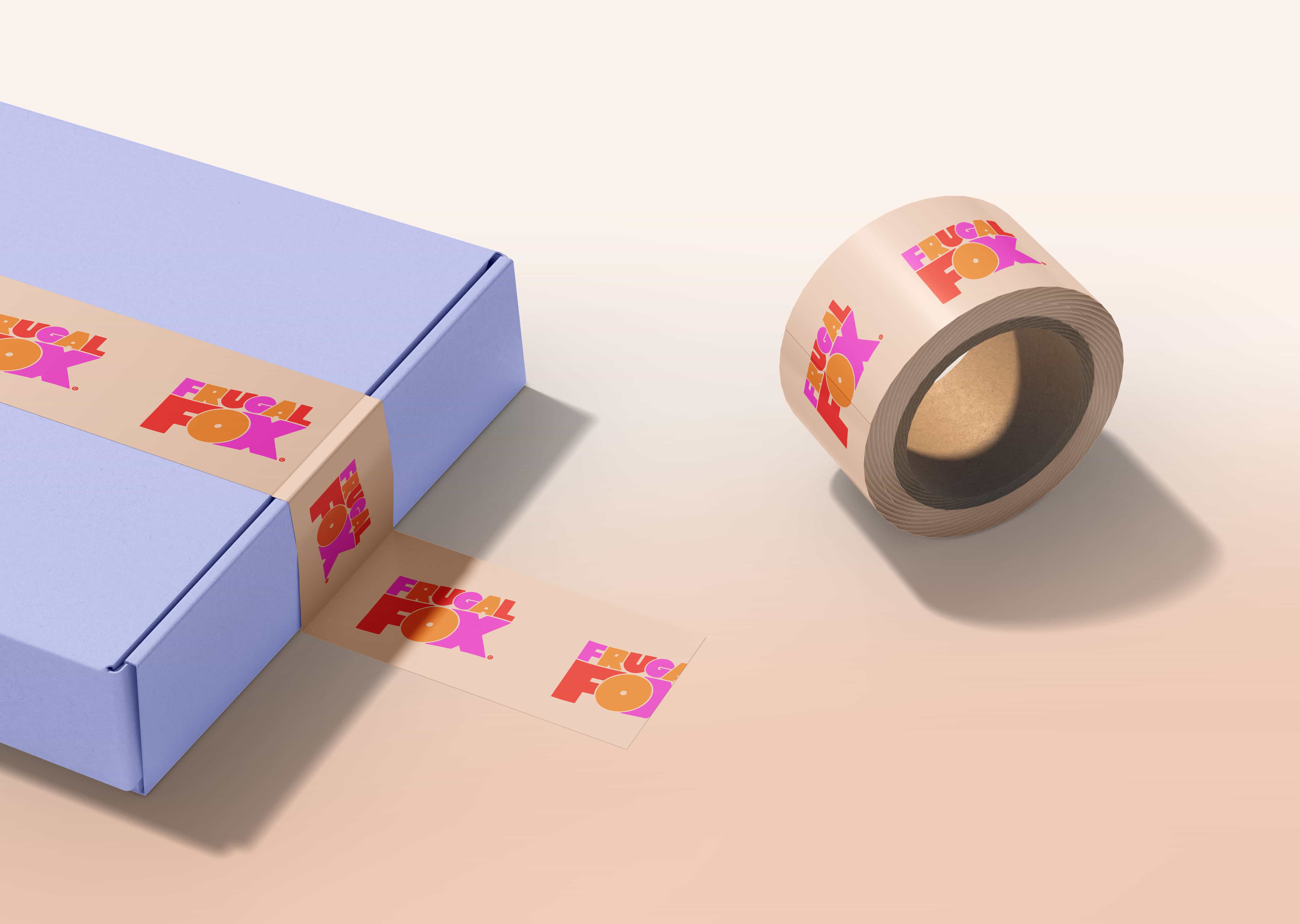 Roll of tan packaging tape with colorful Frugal Fox logo next to a blue box sealed with the same branded tape.