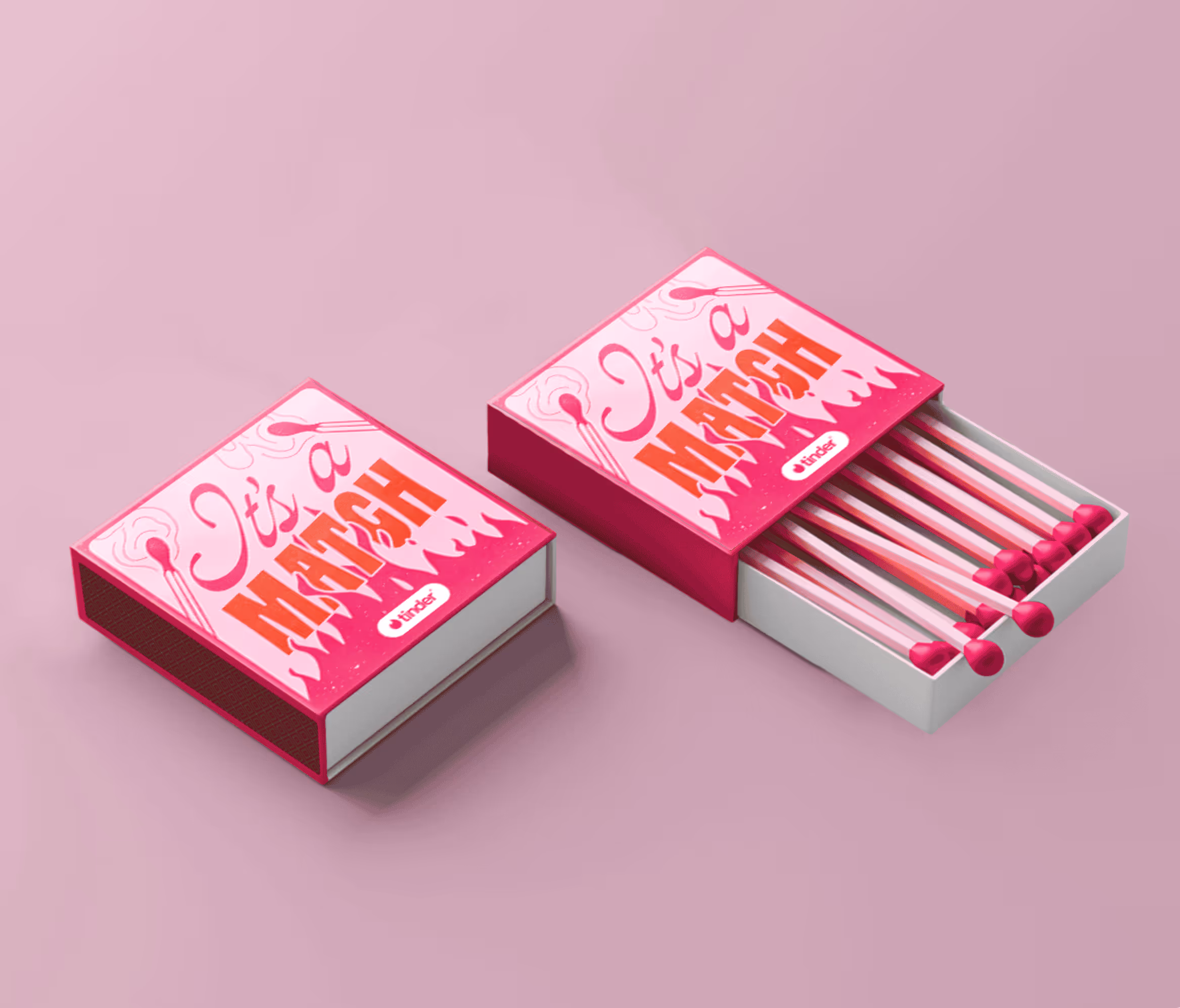 Two pink matchboxes on a pink surface, one closed and one open showing red-tipped matches, with the text 'It's a MATCH' on the cover.