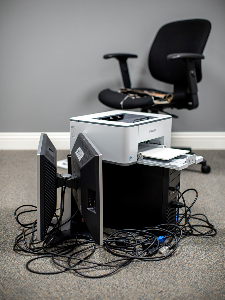 Stack of office electronics and monitors on commercial carpet