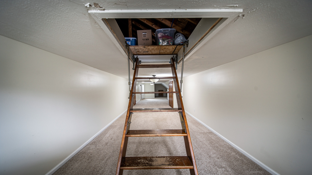 Open attic hatch with pull-down ladder and storage boxes visible in Columbus Ohio home
