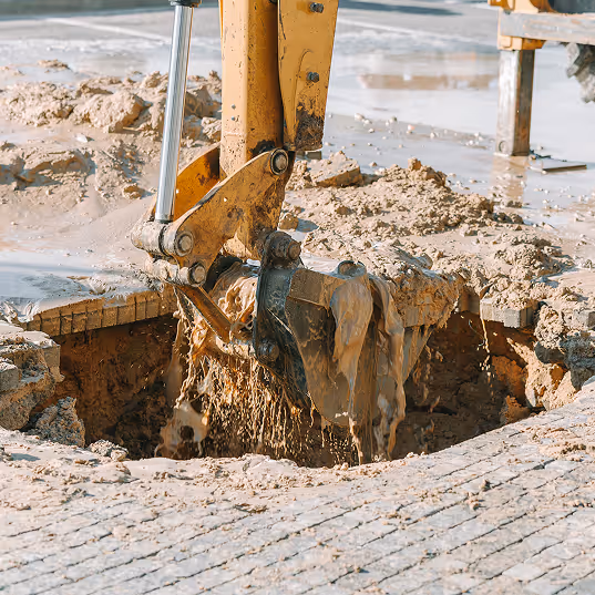 Digger digging up a broken pipe