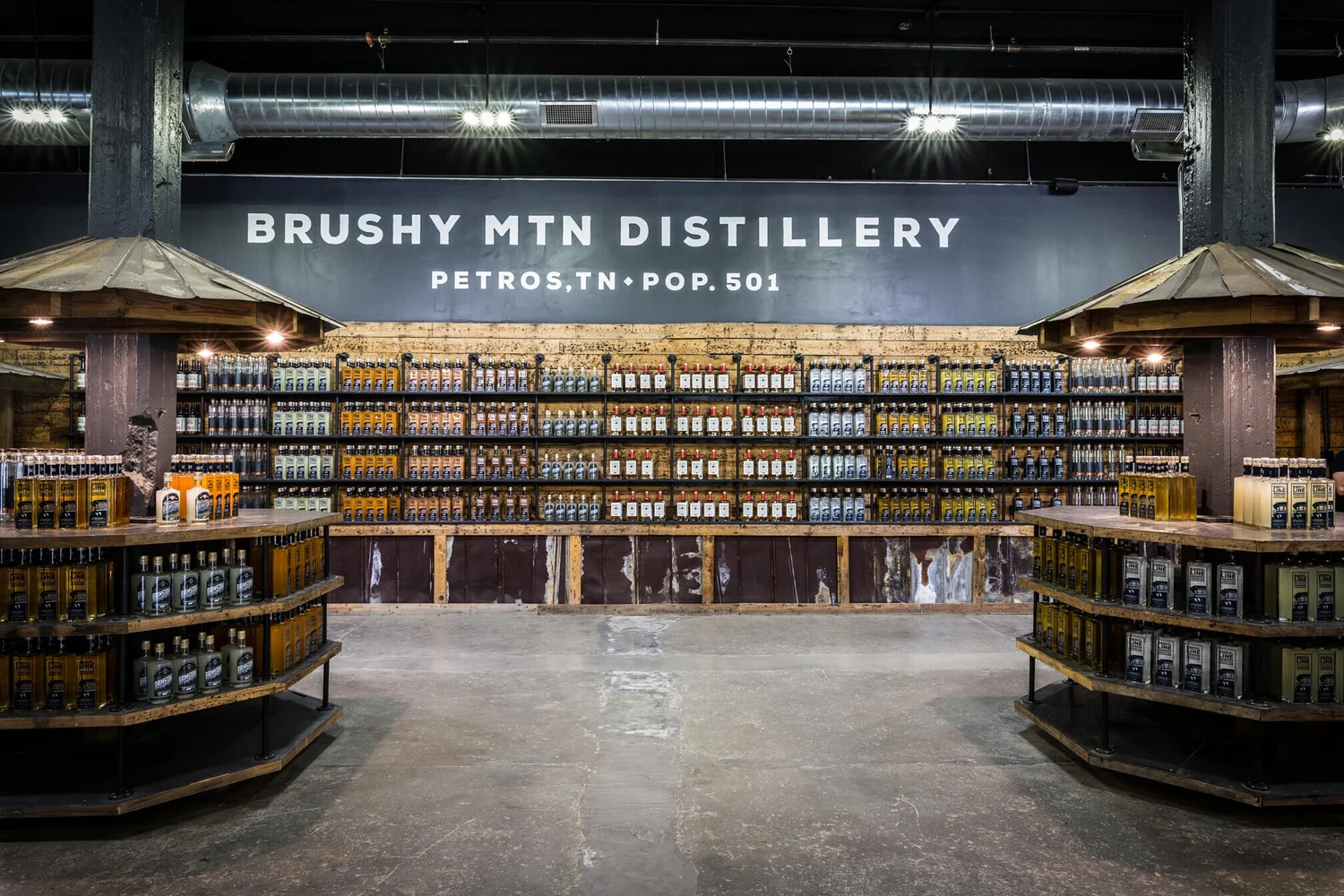 Interior of Brushy Mountain Gift Shop in Petros, TN, showing shelves and tables filled with various bottled spirits.