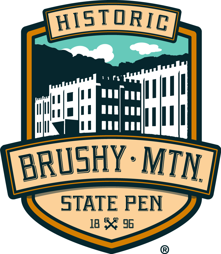 Logo featuring a historic building with the text 'Historic Brushy Mtn. State Pen 1896' and crossed keys icon.
