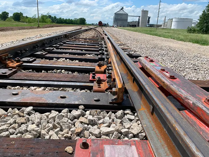 Macro view of a rail with a bioprocessing facility in the background.