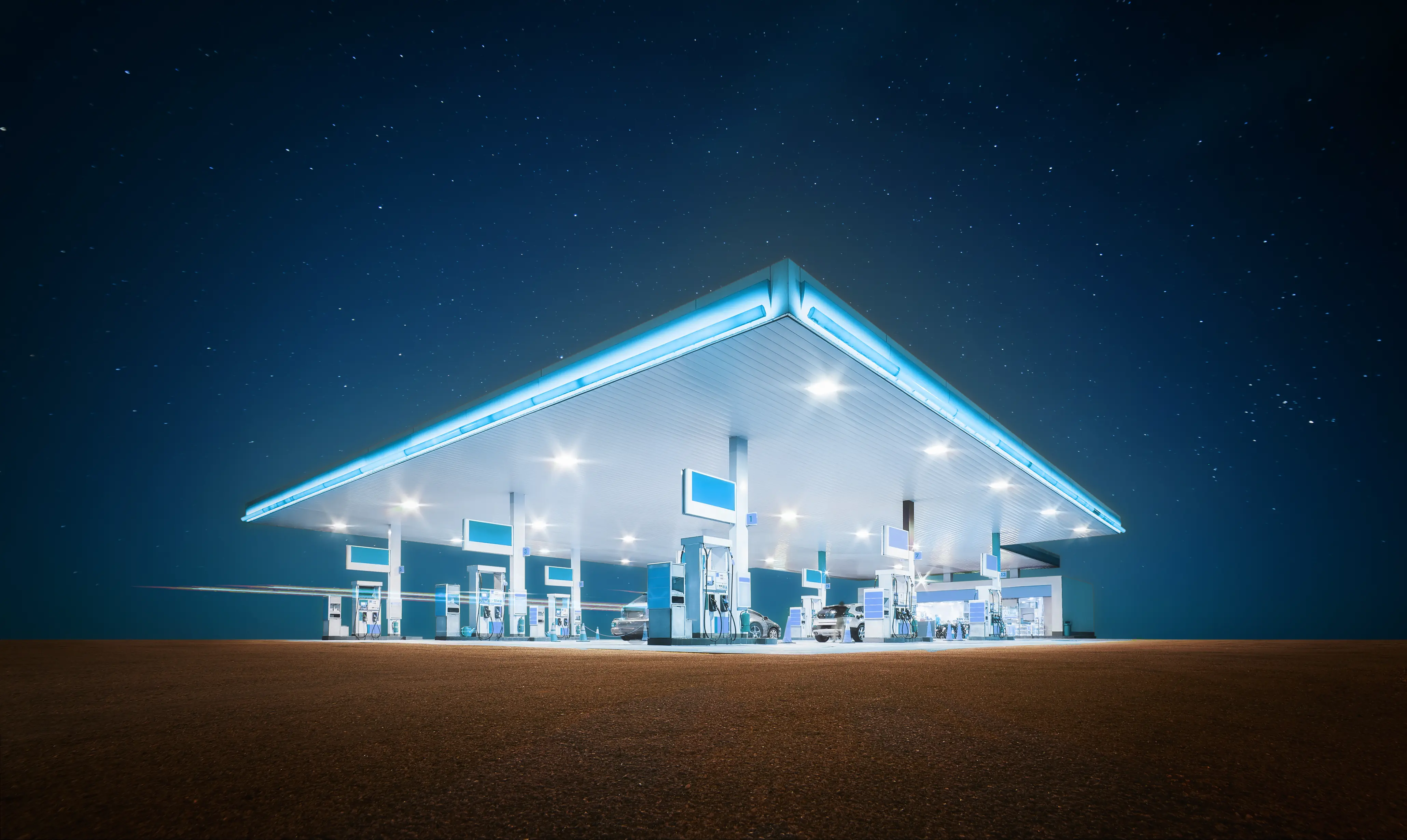 Stylized image of a gas station at night.