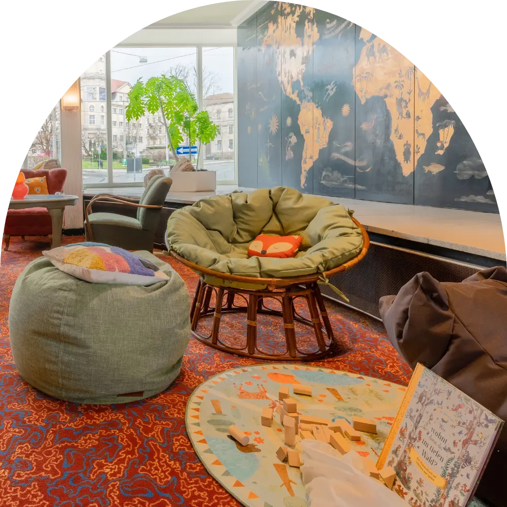 Kinderspielbereich mit Papasan-Sessel, Sitzsack und Weltkarte im Kulturhotel Hessenland Kassel