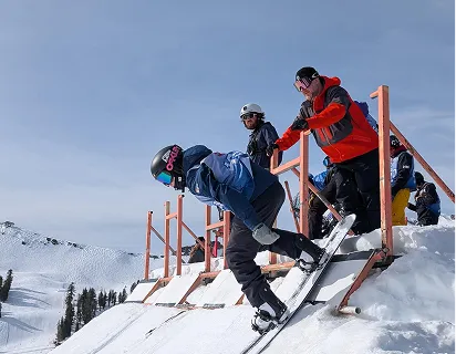 Skiers and snowboarders gathered at the base of a mountain