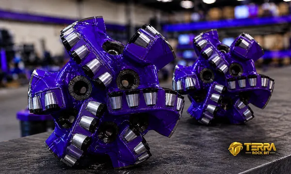 TERRA tricone drill bits in metallic purple finish stacked on pallet, premium HDD rock drilling tools