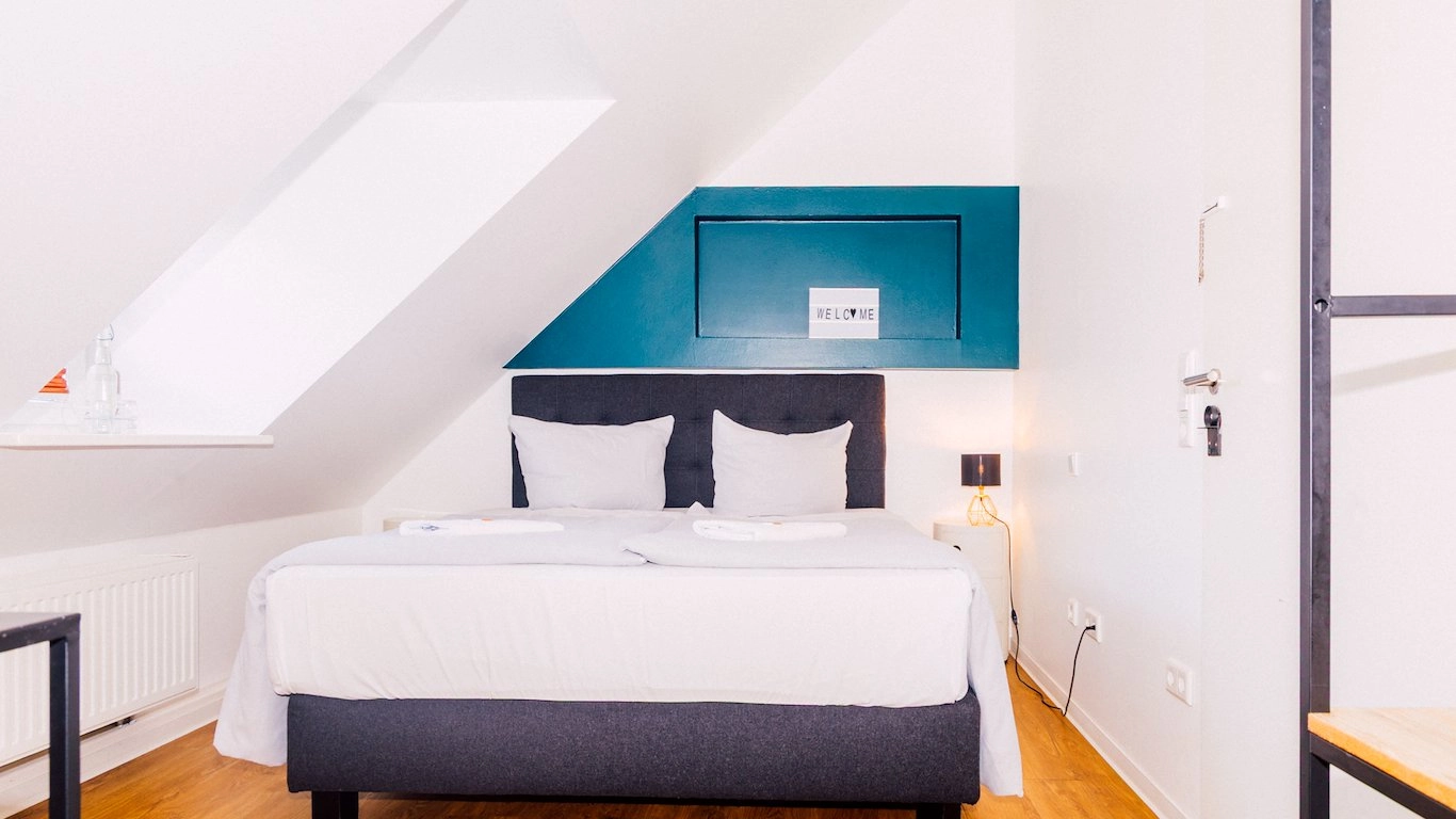 Zimmer Small mit Dachschräge und petrolfarbener Wand im Boutiquehotel Palmenbad Kassel