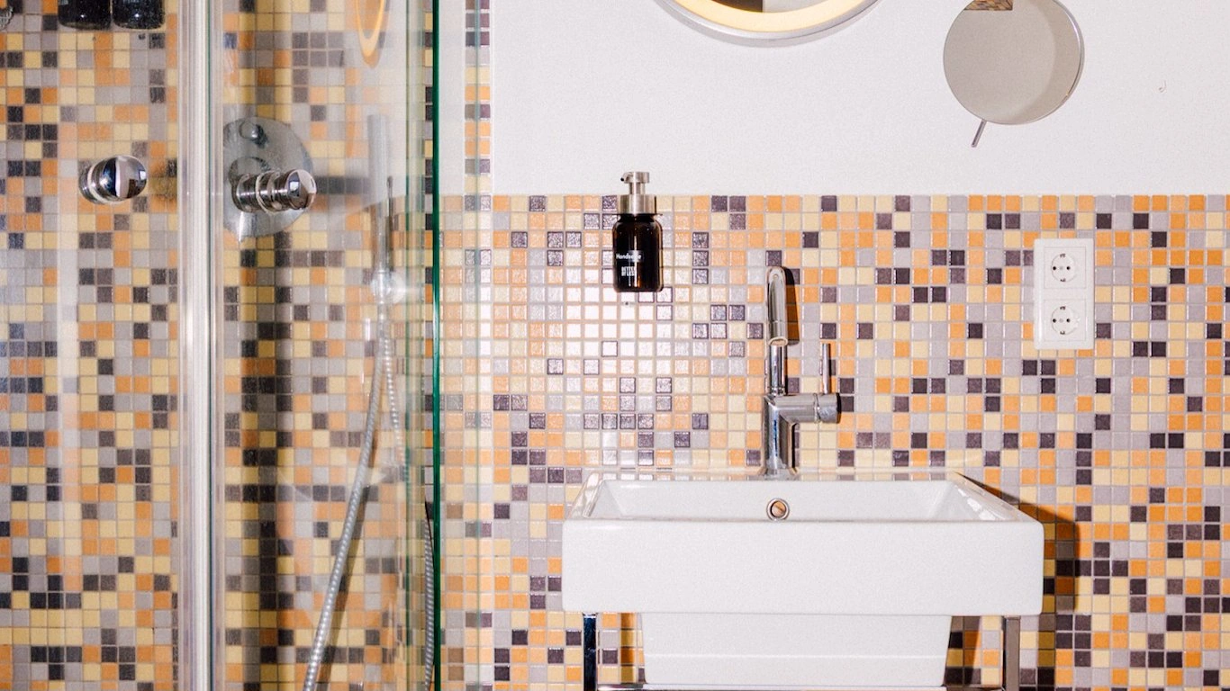 Badezimmer mit Waschtisch und buntem Mosaik im Boutiquehotel Palmenbad Kassel