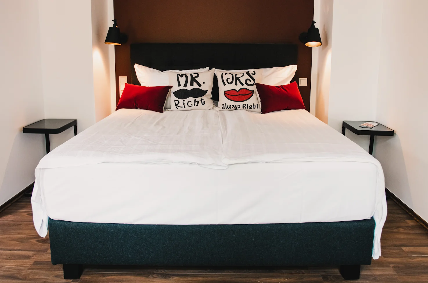 Zimmer Medium mit Mr-and-Mrs-Kissen und brauner Akzentwand im Boutiquehotel Palmenbad Kassel