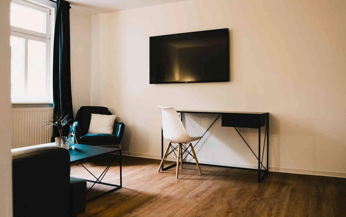 Suite mit Schreibtisch, TV und Lounge-Sessel im Boutiquehotel Palmenbad Kassel