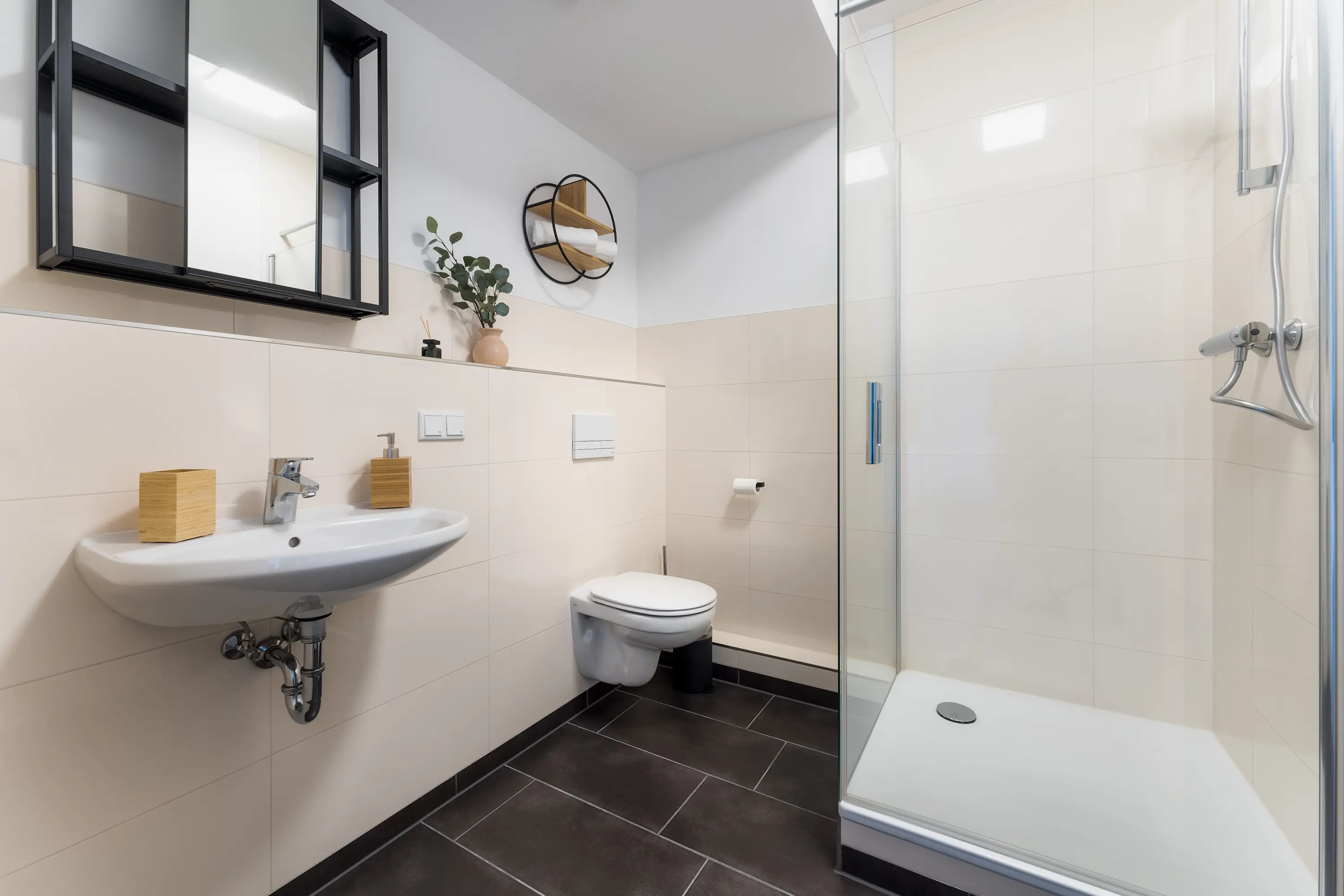 Bad mit Waschtisch, Wand-WC und Glasdusche in den Himmelsstürmer Apartments Kassel.