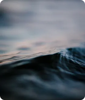 Close-up of a gentle ocean wave with soft focus on the water surface and blurred background.