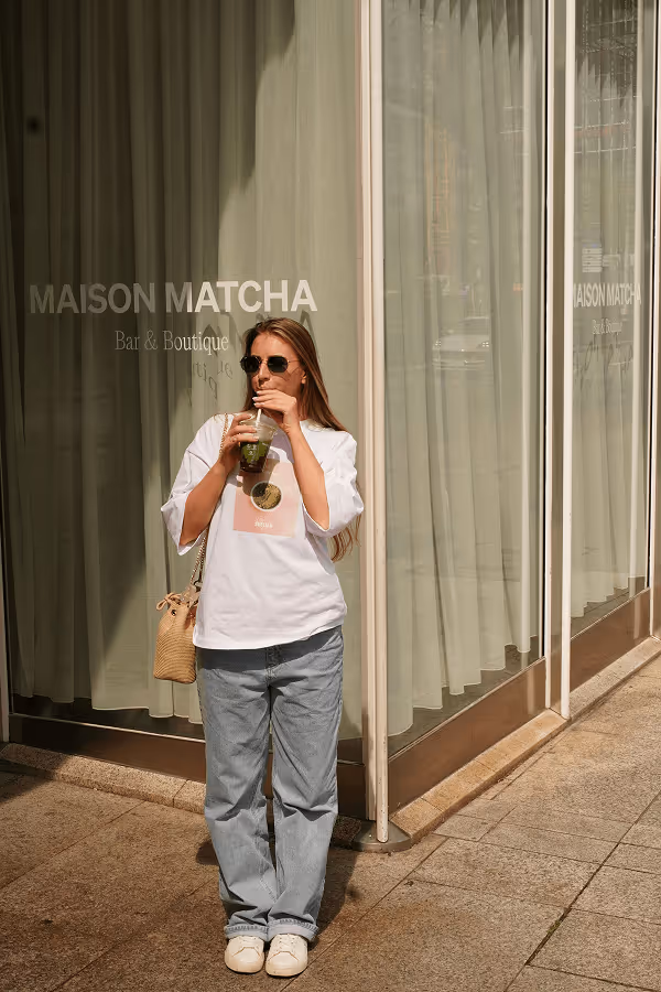 Standing girl sipping on matcha drink