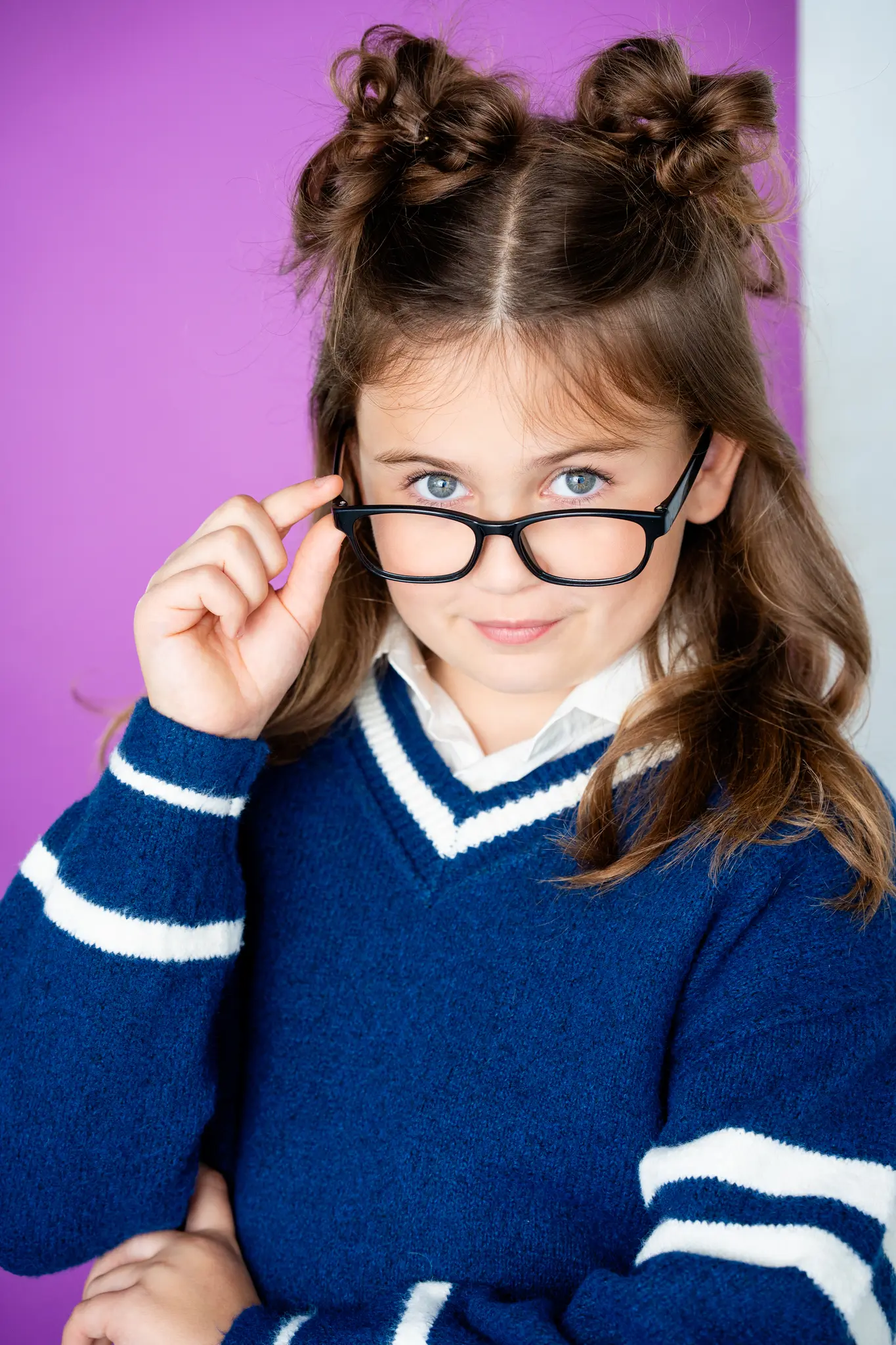 Caroline Brauner studio portrait wearing glasses with character styling against purple background