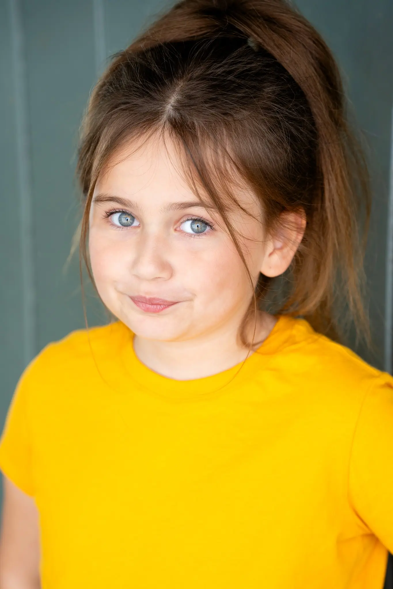 Caroline Brauner casual portrait wearing yellow shirt with hair in ponytail